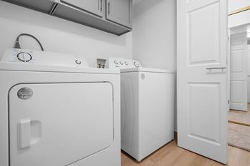 A white washing machine and dryer in a laundry room.